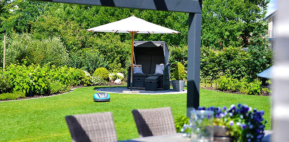 Entspannender Außenbereich mit einem Tisch und Stühlen unter einem großen Sonnenschirm.